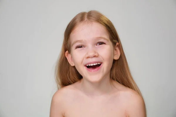 Una niña alegre con el pelo rubio se ríe —  Fotos de Stock