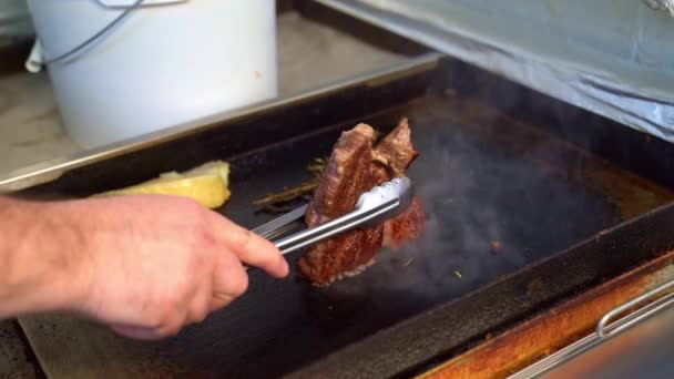 Um chef segurando pedaço assado de carne sobre um fogão . — Vídeo de Stock