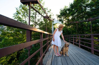 Tahta köprüde başıboş köpeği olan genç bir kız. 