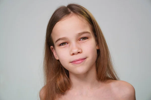 Teen girl with blond hair against a white wall — Stockfoto