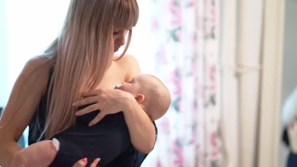 Mother cradles sleeping baby on the hands of home — Stockvideo