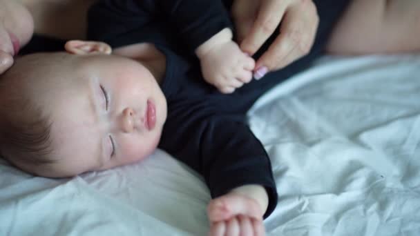 Mom and baby in black sleeping together. close-up. — Stockvideo