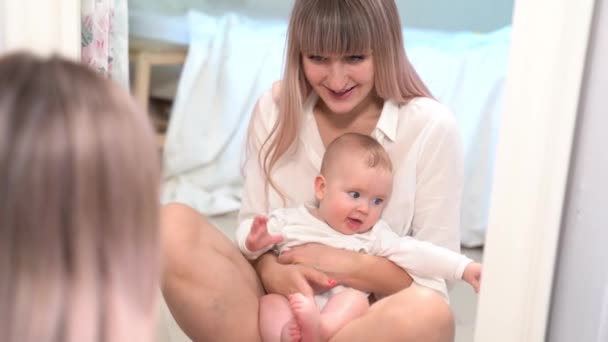 Una mamá con una mirada del bebé en el espejo en dormitorio — Vídeos de Stock