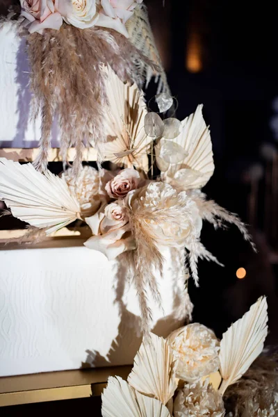 part white square tiered wedding cake with feathers.