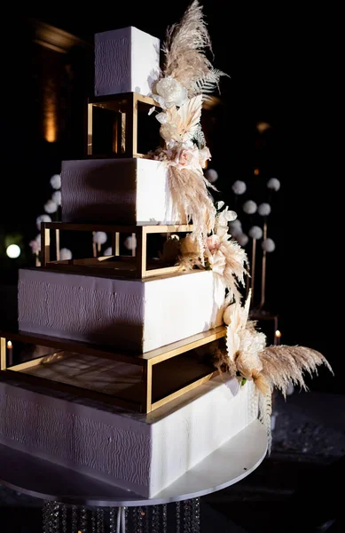 square white tiered wedding cake with feathers.