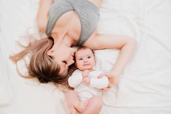 Portrait. maman et bébé s'allongent sur le lit — Photo