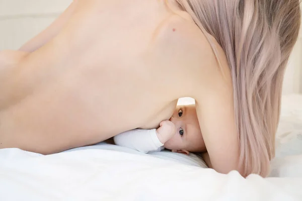 A baby is breastfed eats lying. — Stock fotografie