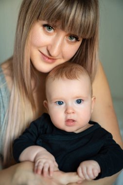 baby in black clothes in the arms of mother.