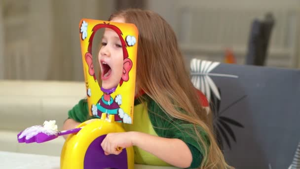 Little girl in dinosaur costume plays pie in face — Stockvideo