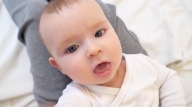 Bebek annesinin ayakları üzerinde yatıyordu ve ellerini kaldırdı.