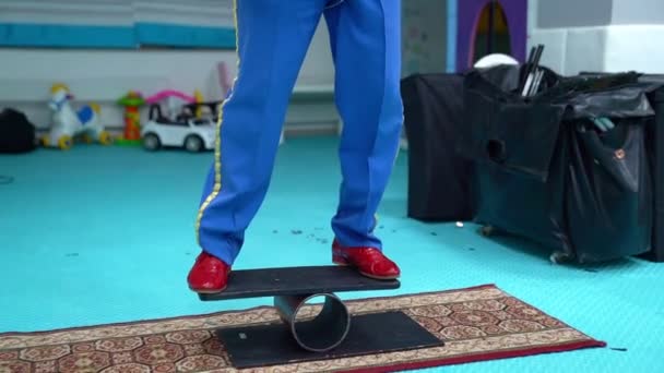 Clown acrobat balancing on the Board and wheel — Stock Video