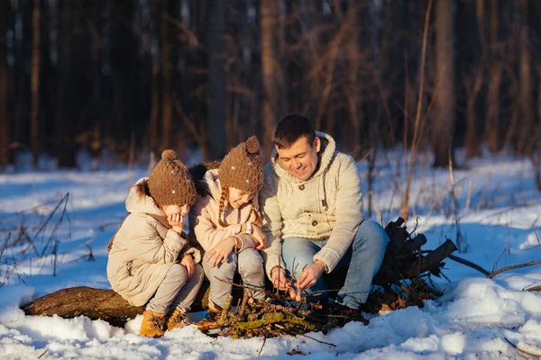 Family roast on the campfire weenies in the winter — Zdjęcie stockowe