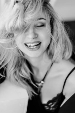 a beautiful blonde girl in black with close eyes.