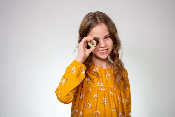 The Teen girl puts one roll to the eye and smiles. — Stockfoto