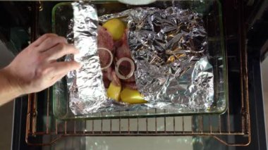 close oven in which foil baked pork neck, potatoes