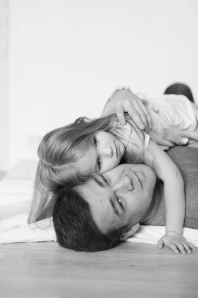 Ayah dan dua anak perempuan tergeletak di lantai. hitam-putih . — Stok Foto