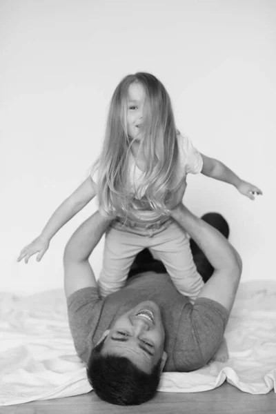 Vater und zwei Töchter am Boden liegend. schwarz-weiß. — Stockfoto