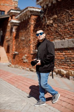 Siyah elbiseli ve sırt çantalı fotoğrafçı.