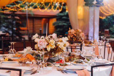 Açık hava çadırında bir masa. Düğün dekoru.