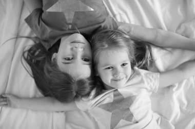 Siyah-beyaz. İki kız kardeş yerde yatıyor.. 