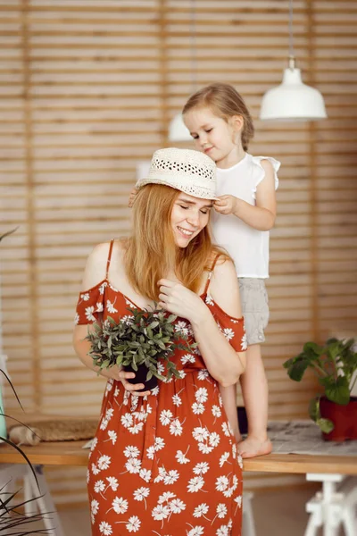 Moeder en dochter met indoor bloemen in de keuken — Stockfoto