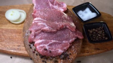 sprinkle ground pepper raw pork on wooden Board