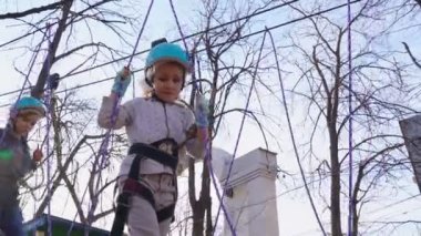 little girl is afraid to climb the rope Park.