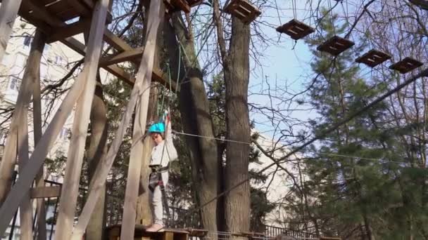 Small girl is afraid, learns to climb rope Park. — Stock video