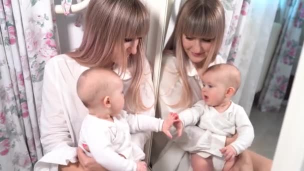 Mother with a baby look in the mirror in bedroom — Stockvideo