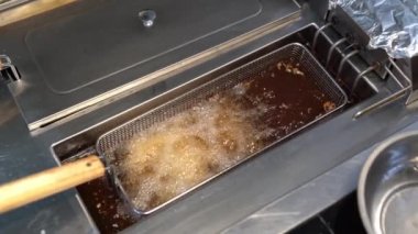 Boiling oil in deep fryer in kitchen. Fast food.