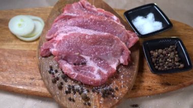 sprinkle the raw pork with salt on wooden Board