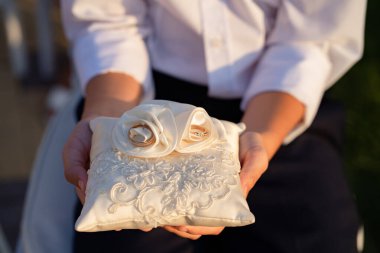 Beyaz bir yastıktaki alyanslar ve kumaş güller