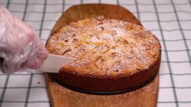 White knife cuts a piece of homemade cake
