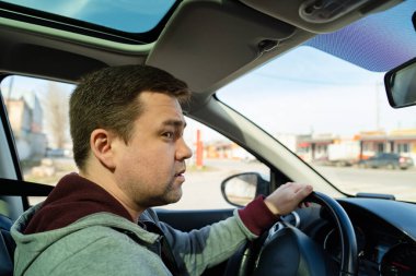 Gri kazaklı şaşkın adam direksiyon başında