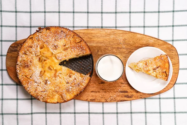 Tagliare parte torta fatta in casa e latte di vetro di legno — Foto Stock