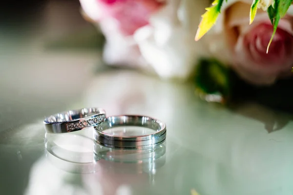 Anillos con gotas de agua sobre fondo de ramo — Foto de Stock