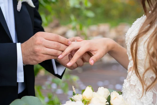 Braut und Bräutigam ziehen sich gegenseitig Ringe an. — Stockfoto