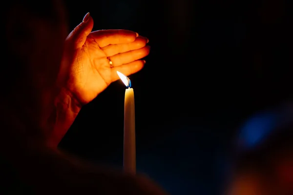 Kadın eli söner, karanlıkta mum yakar.