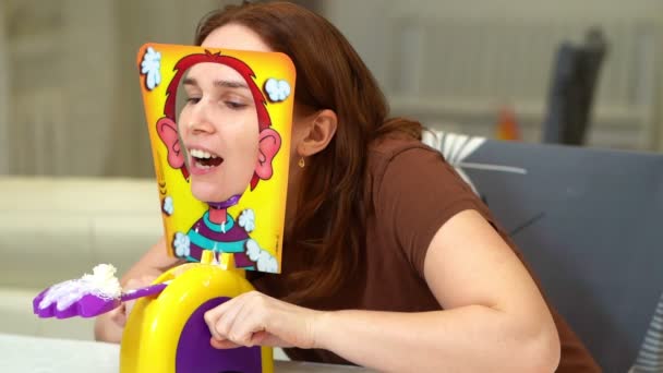 Woman in a brown t-shirt playing a pie in face — Stock Video