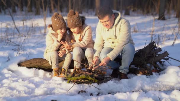 Family roast on the campfire weenies in the winter — Wideo stockowe