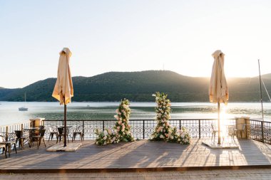 Gölün arka planında seremoni için çiçek kemeri