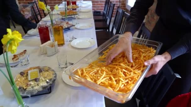 Офіціант в рукавичках кладе тарілку картоплі фрі . — стокове відео
