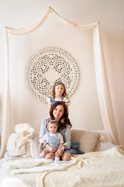 Madre con hijas jugando en la cama. sesión de fotos . — Foto de Stock