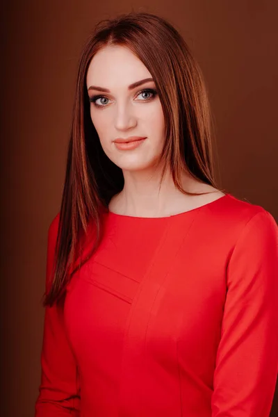 Flicka med långt hår i rött på mörk bakgrund — Stockfoto