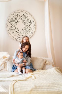 Anne ve kızları yatakta oynuyorlar. photoshoot.