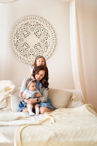 Madre con hijas jugando en la cama. sesión de fotos . — Foto de Stock