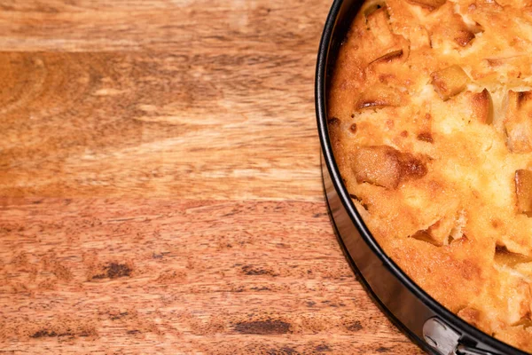 Frammento di torta fatta in casa in padella su tavola di legno . — Foto Stock