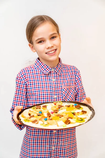 Девушка-подросток держит сковородку с сырой сладкой пиццей — стоковое фото
