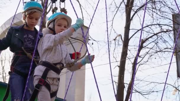 Little girl is learning to climb the rope Park. — Stock Video