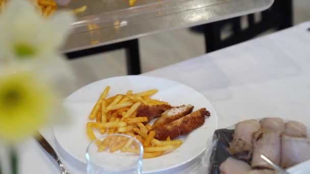 Primer plano camarero usando guantes pone plato de papas fritas — Vídeos de Stock